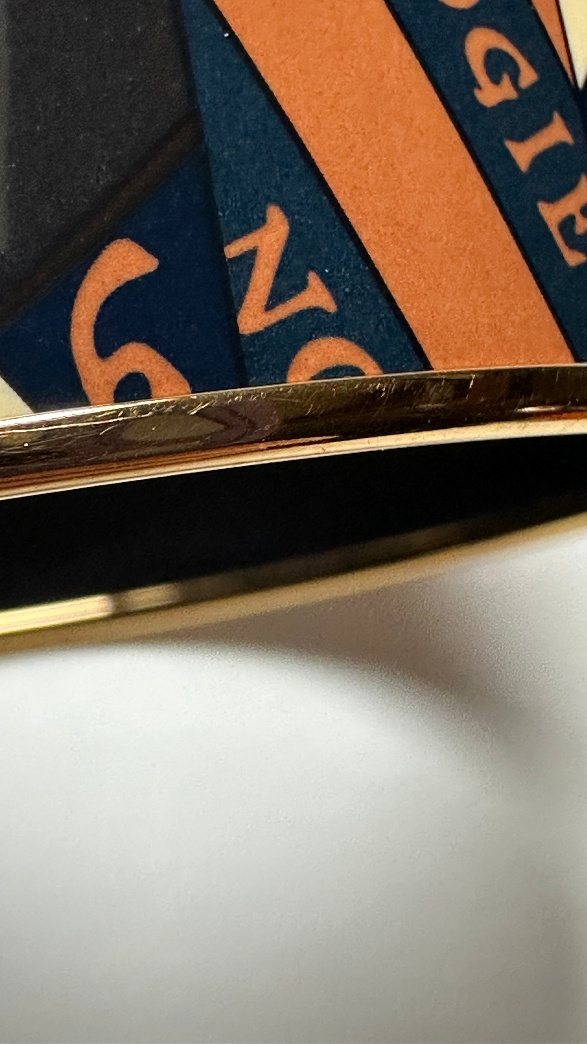 Gros plan motif soleil et zodiaque sur émail Hermès Astrologie Nouvelle