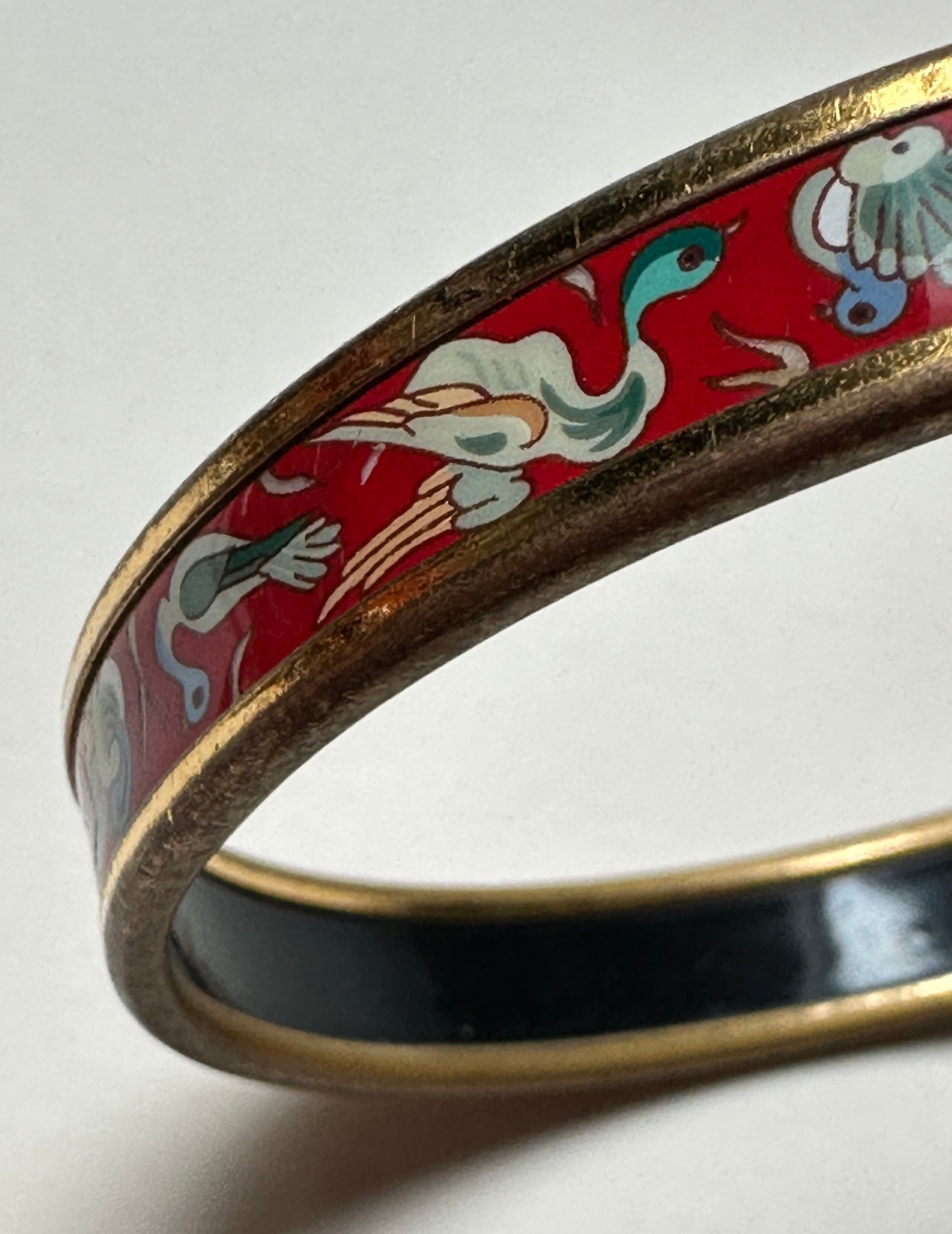 Bracelet rigide Hermès femme, modèle jonc fin (Narrow) rouge et or, illustration d'oiseaux à l'envol.
