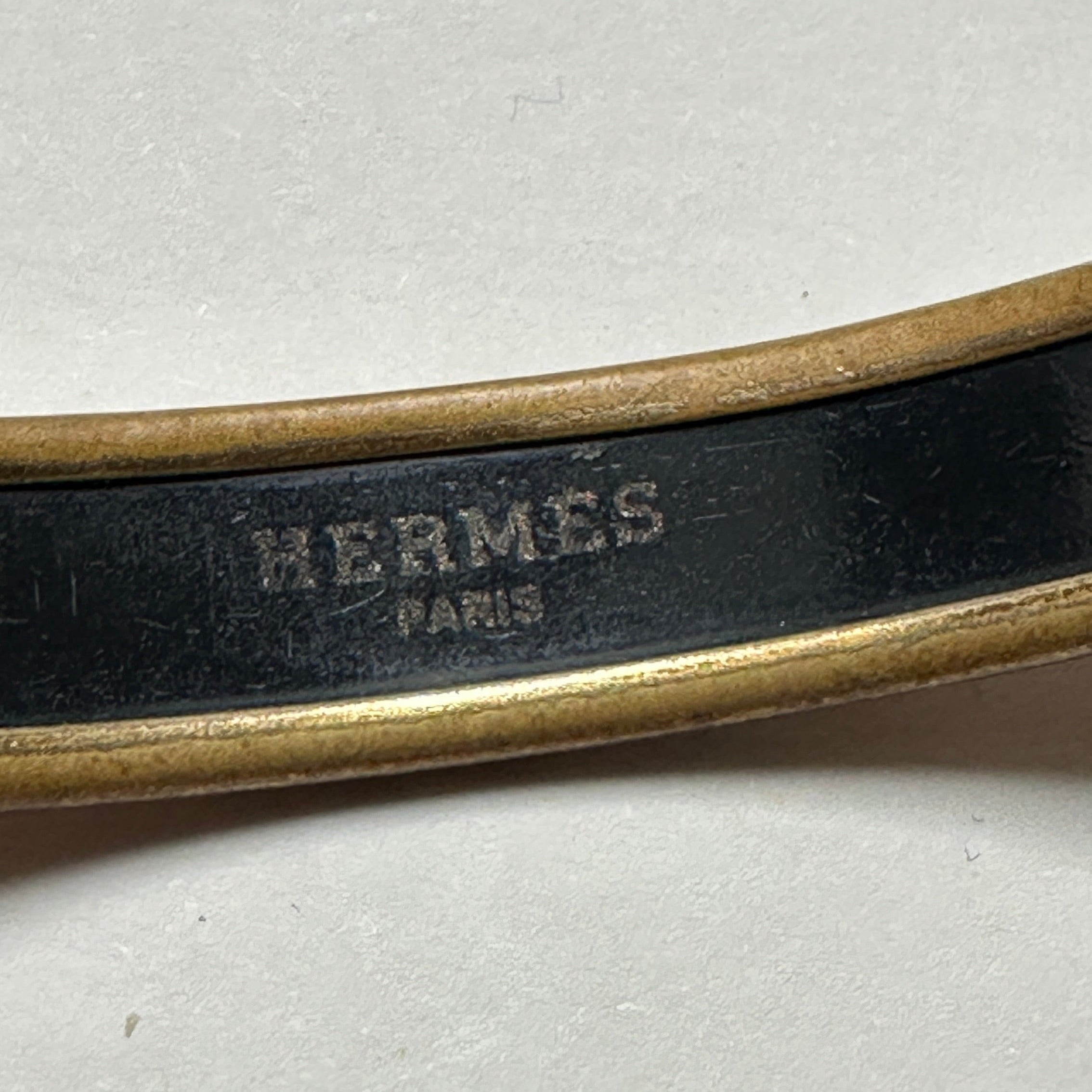 Logo Hermès Paris gravé en lettres dorées à l'intérieur du bracelet jonc vintage.